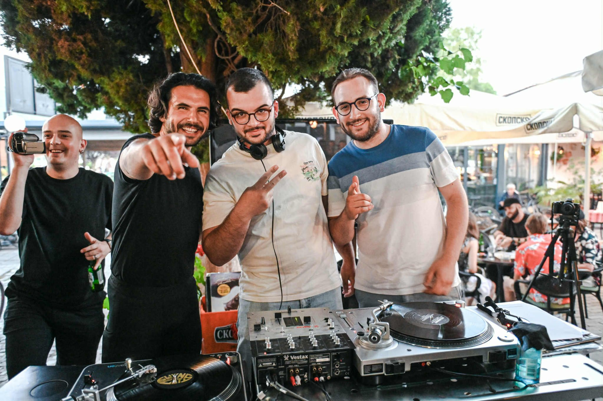 Trim Biba behind the turntables with friends at an outdoor daytime set