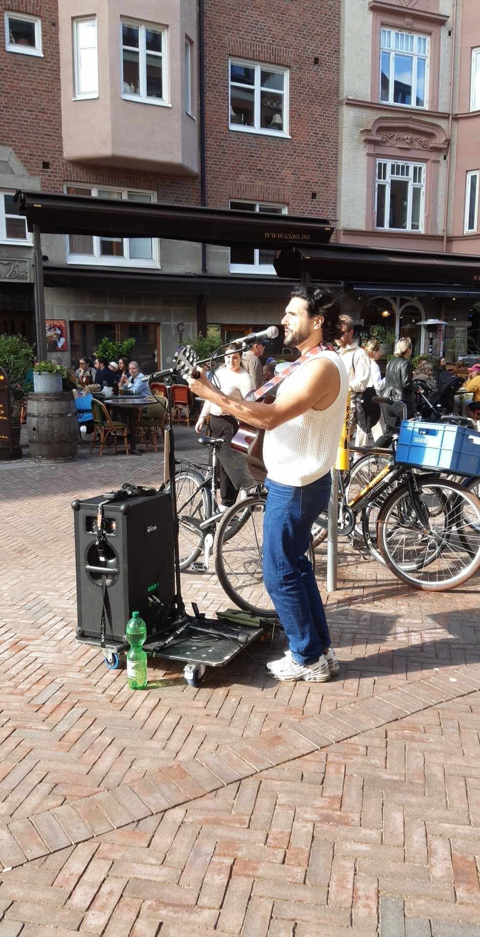 Trim Biba playing guitar and singing on a square in Malmö